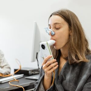 Young woman with doctor during a spirography test, measuring breathing movements with spirometer at medical Spa salon