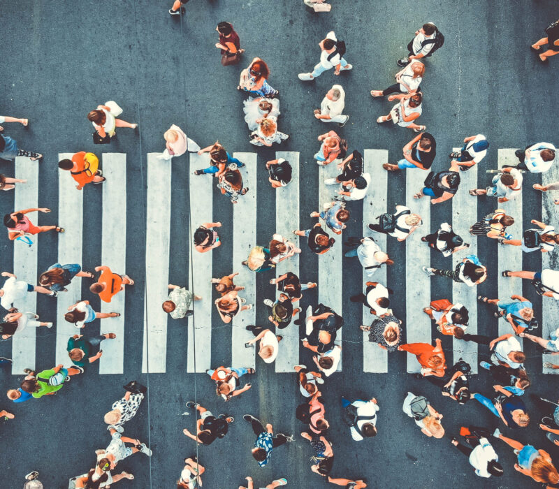Aerial. People crowd on pedestrian crosswalk. Top view background. Toned image.